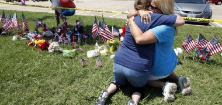 Maynard hugs her friend Atterton beside a growing memorial at the Armed Forces Career Center in Chattanooga